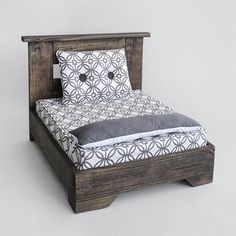 a bed that is made up with pillows on top of the headboard and foot board