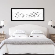 a bedroom with a bed and two lamps on either side of the bed that says let's cuddle