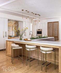 a kitchen island with four stools in front of it and an oven on the other side