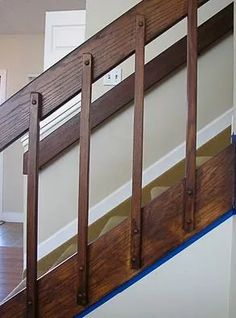 an empty room with wooden railings and hard wood flooring on the bottom level