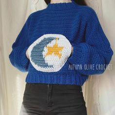 a woman wearing a blue sweater with an orange star on it