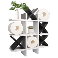 a white shelving unit with four rolls of toilet paper and a potted plant