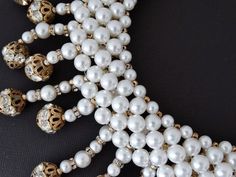 "This incredible collar necklace is unsigned, however, it is attributed to either Coppola e Toppo, Mimi D'N, or Hattie Carnegie. Whoever the designer, it is fabulous and done with incredible talent, artistry, and quality construction Look at the back side constructiongorgeous glass pearl bead strings are mounted onto a weft (like Coppola e Toppo) of glass pearls. The strings are made up of glass pearls, rhinestone rondelles, and rhinestone rondelle balls. There is some color wear to the gold pla Luxury White Pearl Necklace For Party, Luxury Pearl Embellished Necklaces For Parties, White Beaded Necklaces For Evening, White Beaded Bridal Necklace For Evening, Luxury White Necklaces For Party, Luxury White Necklace For Party, Glamorous White Bridal Necklace Gift, Glamorous White Bridal Necklace For Formal Occasions, Glamorous White Bridal Necklace For Anniversary