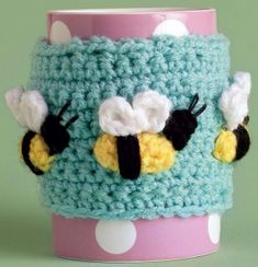 a crocheted cup holder with two bees on it