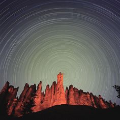 the stars are in the sky above some rocks