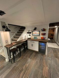 an empty kitchen and living room with stairs leading up to the second floor in this home