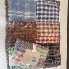 four different colored plaid pillows sitting on top of each other