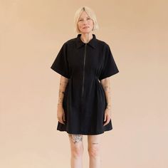 On a tan background is a model wearing a black zip up dress with short sleeves and a collar. Utility Dress, Oversized Sleeves, Oversize Sleeves, Upcycled Denim, Overall Dress, Dress Suits, Buy Dress, Cinched Waist, Leisure Wear