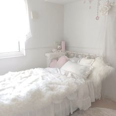 a bedroom with white walls and fluffy bedding