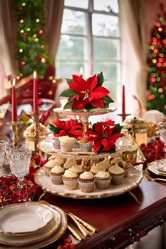 a christmas table setting with cupcakes, muffins and poinsetti