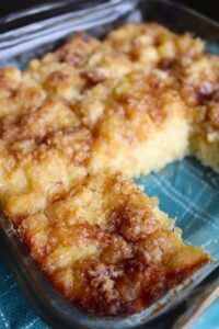 a close up of a cake in a pan on a blue cloth with a fork