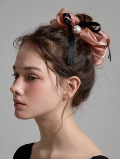 a woman wearing a black and pink hair bow