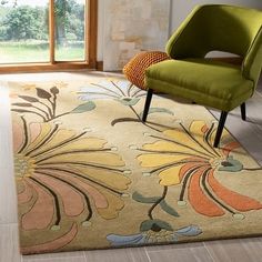 a green chair sitting on top of a rug in a living room next to a window