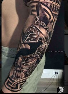 a man's arm with a black and grey tattoo design on it, including an eagle