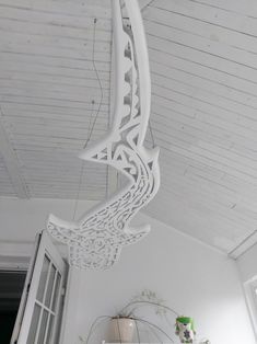 an intricately designed light fixture hangs from the ceiling in a room with white walls and ceilings