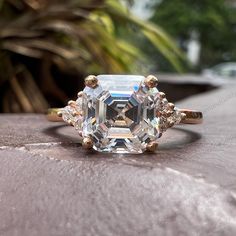 an engagement ring with a large diamond surrounded by smaller diamonds on the outside of it