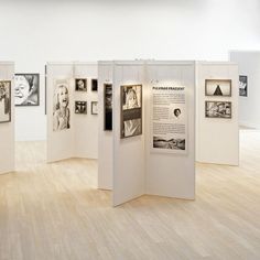 an art gallery with white walls and pictures on the wall, all displaying black and white photographs