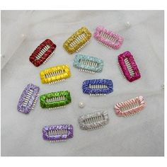 many different colored hair clips on a white surface