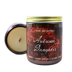 an autumn bouquet candle in a glass jar with a lid on the front and inside