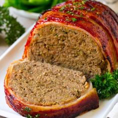 the meatloaf is sliced and ready to be eaten on the plate with parsley