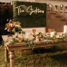 a table with candles and flowers on it in front of a sign that says the stationers