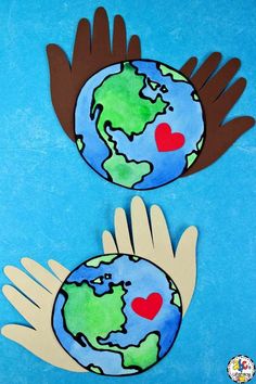 two hands are holding the earth with hearts on it, and one hand is wearing gloves