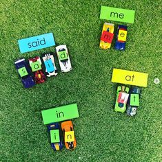 four toy cars sitting on top of green grass next to words that spell out the word said in at