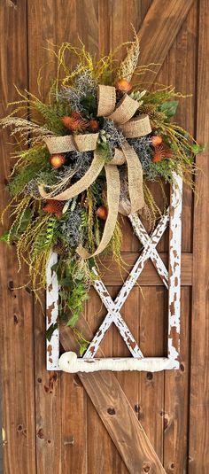 a wooden door with a wreath hanging on it's side and an old window frame