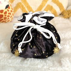 a small black bag with gold stars on it sitting on a white furnishing