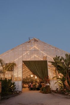 the inside of a building with lights on it and people sitting at tables in front