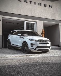 a white range rover parked in front of a building