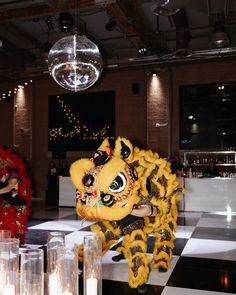 a yellow and black dragon statue sitting on top of a checkered floor next to candles