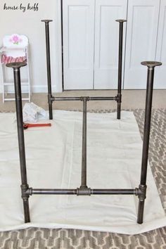 an iron pipe bed frame sitting on top of a rug