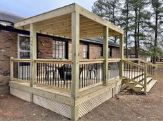 a wooden deck with railings next to a brick building