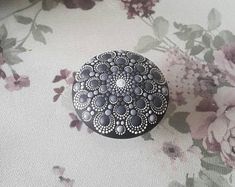 a black and white flowered design is on the fabric next to a small button