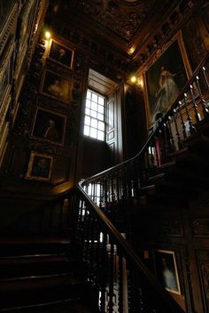 the staircase in an old building with paintings on it's walls and stairs leading up to