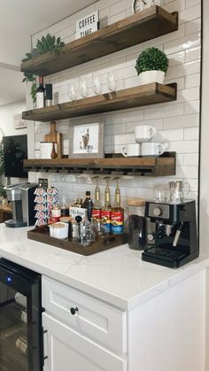 a kitchen counter with shelves above it and coffee cups on the shelf next to it