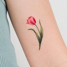 a single pink tulip tattoo on the arm