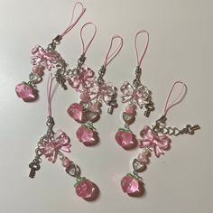 six pink heart shaped charms with crystal hearts and keys hanging from the end of each bead