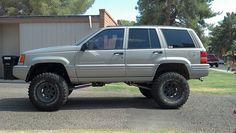 a silver jeep parked in front of a building