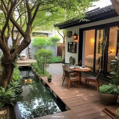 a patio with a table and chairs next to a small pond in the middle of it