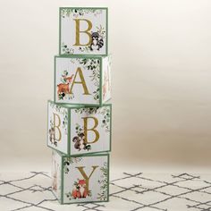 three wooden blocks with animals on them and the letters baby spelled out in gold lettering