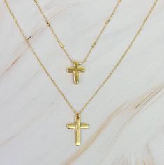 This set of two necklaces features a pretty chain and modern cross design. Versatile and stylish, these necklaces can be worn together for a complementing look or separately to make a statement. Elevate any outfit with this must-have accessory set. Dimensions: approximately 16", 18" chains. Each chain comes with a 3" extender Plated alloy metal Lead and Nickel compliant Trendy Cross Necklace With Adjustable Chain, Adjustable Cross Necklaces With Delicate Chain, Adjustable Cross Necklace With Delicate Chain, Adjustable Delicate Chain Cross Necklaces, Metal Cross Charm Necklace, Adjustable Clavicle Chain Cross Necklace, Chain Cross Necklace, Two Necklaces, Cross Design