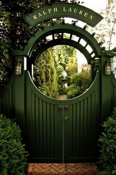 a green gate with a sign that says kalphauern on it and some bushes around it