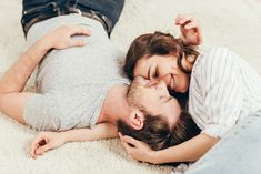 a man and woman are laying on the floor with their heads close to each other