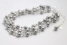 Our Silver Elegance necklace is a stunning accessory that pays tribute to classic elegance with its graceful, cascading strands of pearls, rhinestones and crystals. Featuring gorgeous Swarovski© glass pearls in different hues, a sparkling rhinestone ball and Swarovski© Crystals. Silver chain is adjustable ready to fit any outfit. Make it your own, and wear it in any way that suits you. Elegant Beaded Silver Bridal Necklace, Elegant Silver Bridal Necklace With Round Beads, Elegant Silver Beaded Necklaces With Round Beads, Silver Beaded Necklace With Rhinestones For Wedding, Silver Single Strand Pearl Necklace For Evening, Elegant Silver Multi-strand Beaded Necklaces, Elegant Silver Beaded Necklaces With Rhinestones, Elegant Silver Beaded Necklace With Rhinestones, Elegant Beaded Multi-strand Bridal Necklace