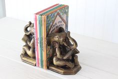 an elephant bookend sitting on top of three books