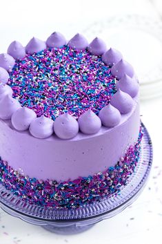 a cake with purple frosting and sprinkles