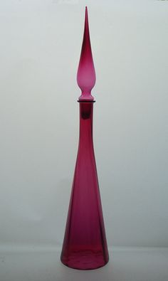 a pink vase sitting on top of a white table