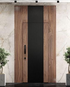 a large wooden door sitting next to two planters